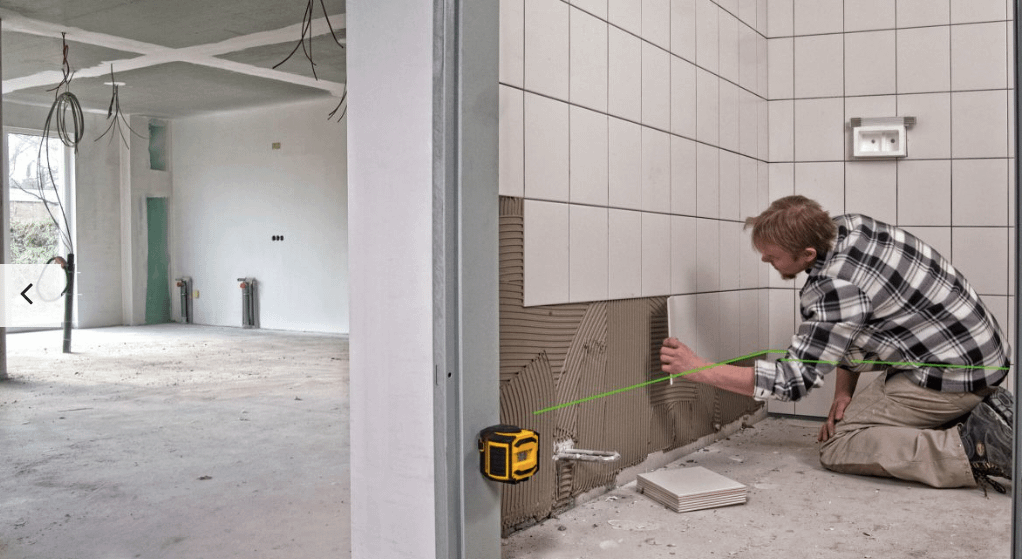Worker Applying Tile with Stabila Green BEam laser